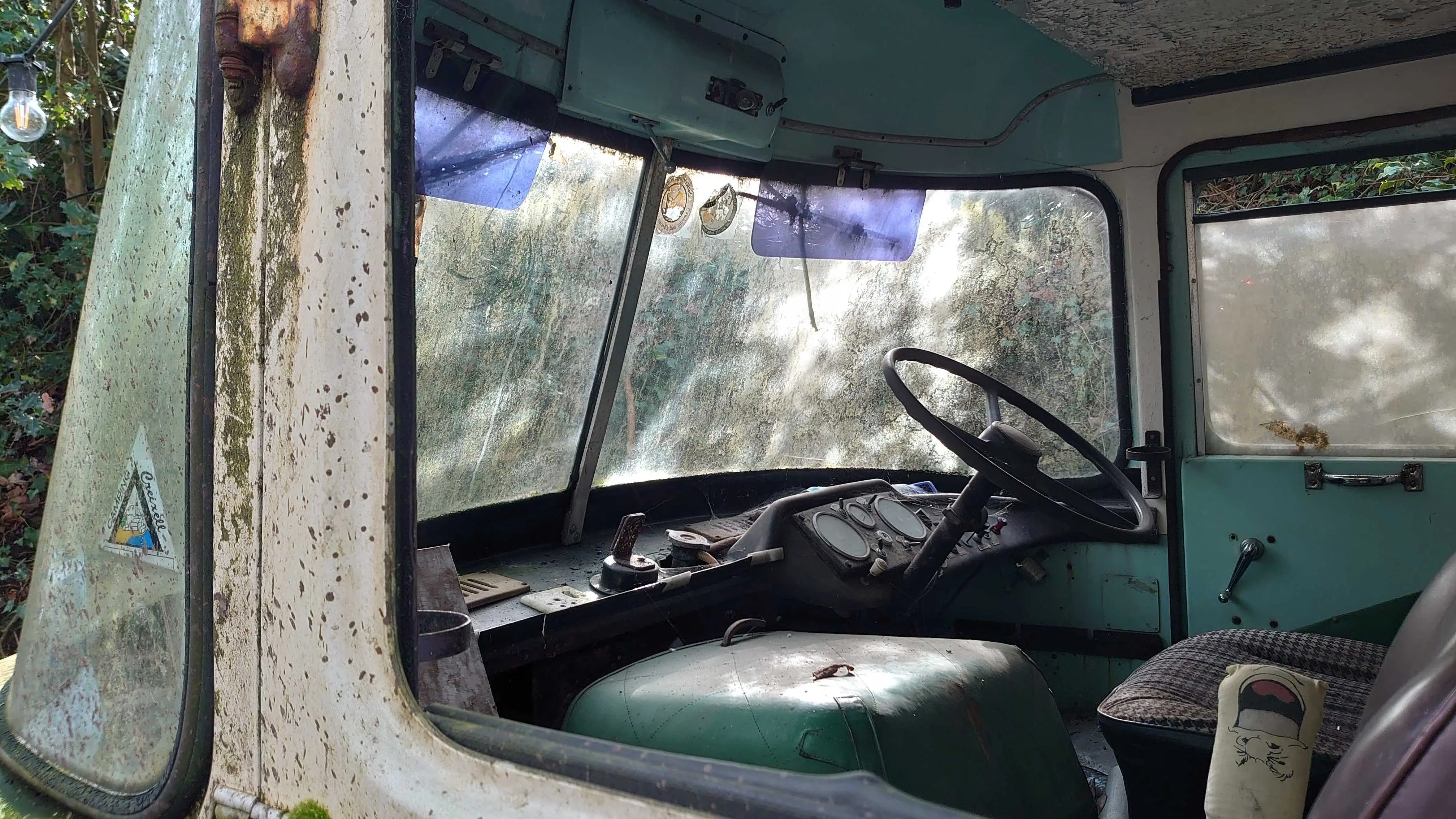 An abandoned 1950s era van cabin, viewed through the passenger window