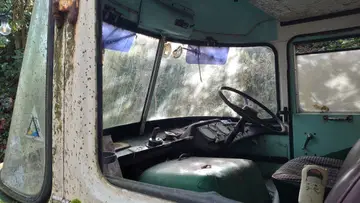 An abandoned 1950s era van cabin, viewed through the passenger window